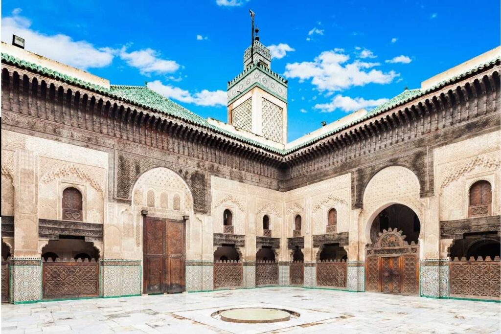 Courtyard of Bou Inania Madrasa in Meknes with carved arches and traditional Moroccan tilework