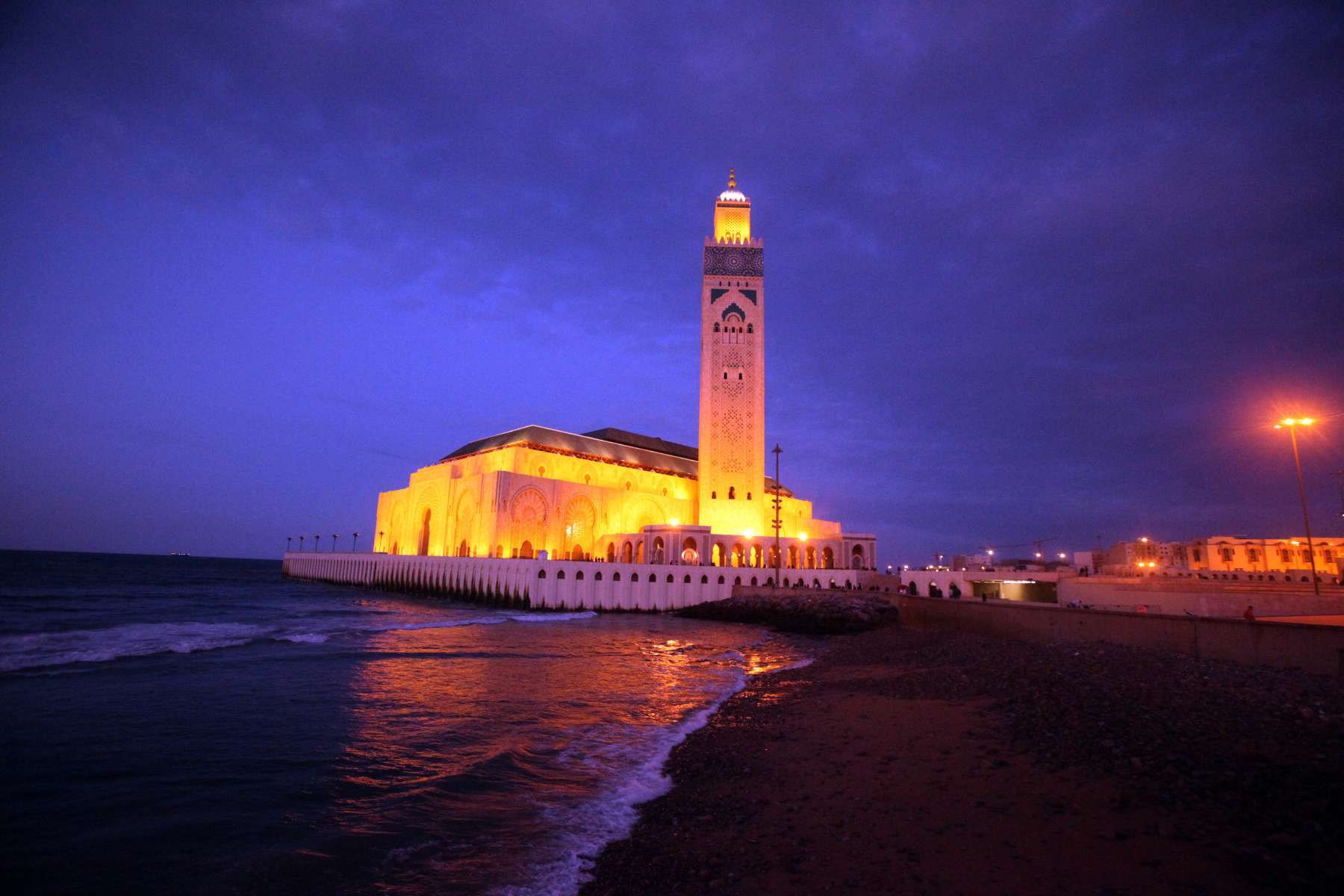 Hassan II Mosque in Casablanca illuminated at sunset beside the Atlantic Ocean