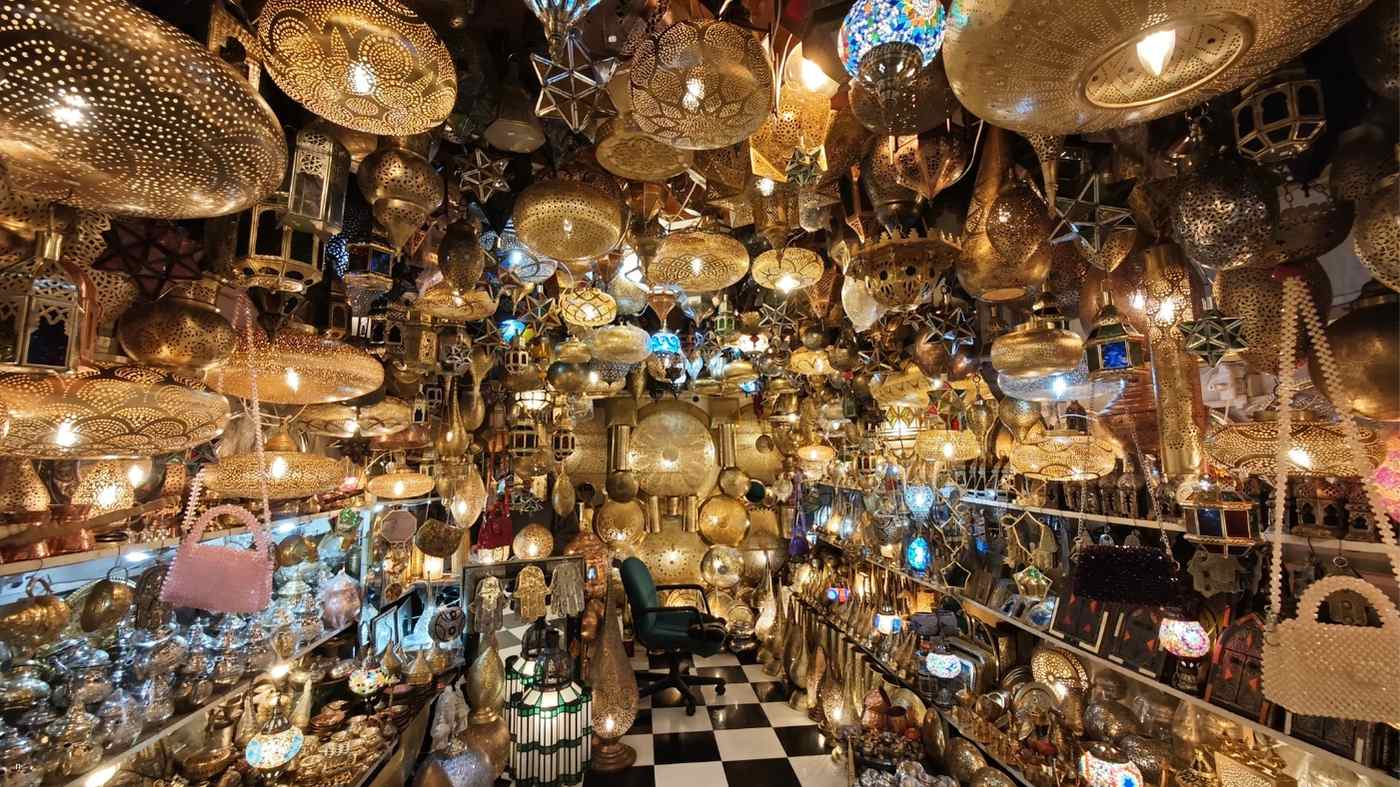 Traditional Moroccan lantern shop in the souks with handmade brass lamps and colorful glass lights