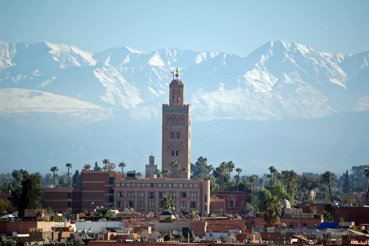 Koutoubia Mosque in Marrakech with Atlas Mountains in the background representing Morocco tours and landscapes
